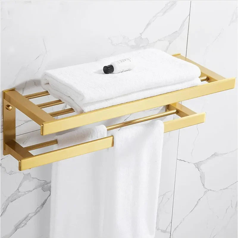 Gold towel rack with white towels on a marble bathroom wall