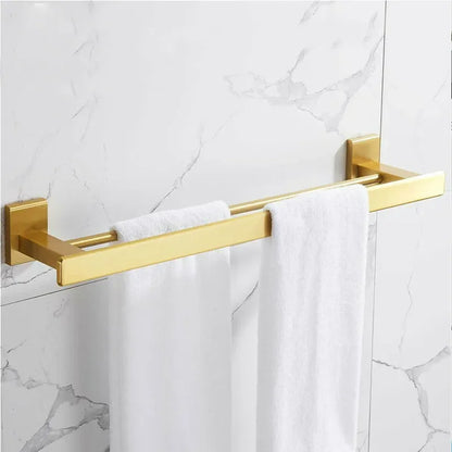 Gold towel rack with white towels on a marble wall