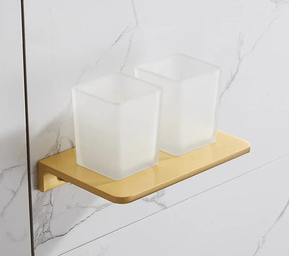 Gold soap dish with three white soap bars on a tiled bathroom wall.