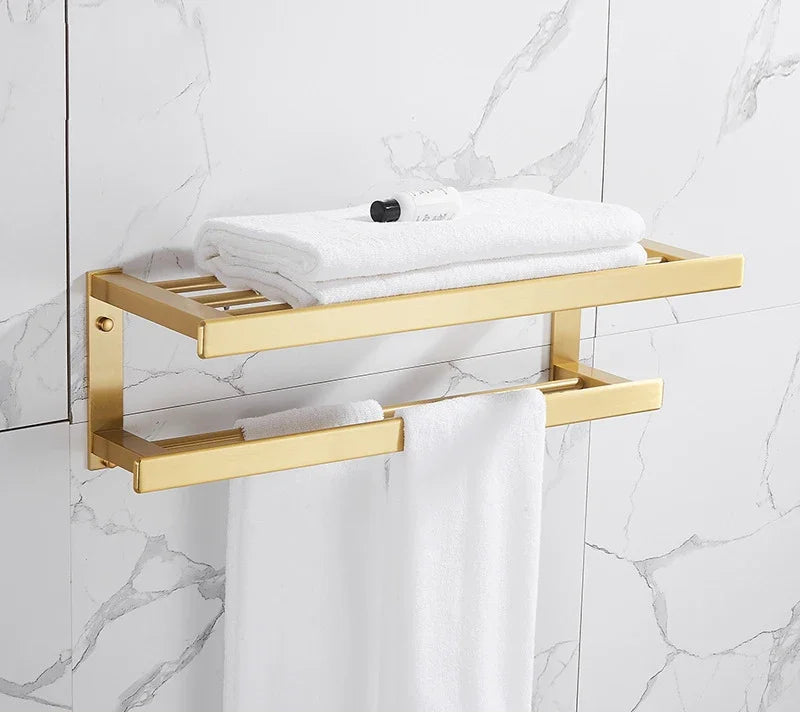 Gold towel rack with white towels on a marble bathroom wall