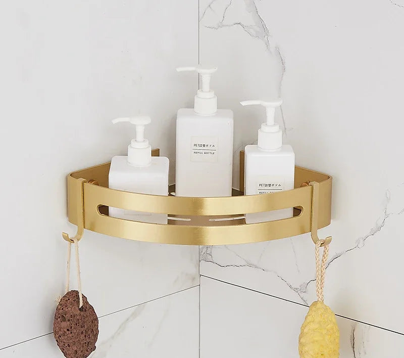 Gold corner shelf with bathroom products on a tiled wall