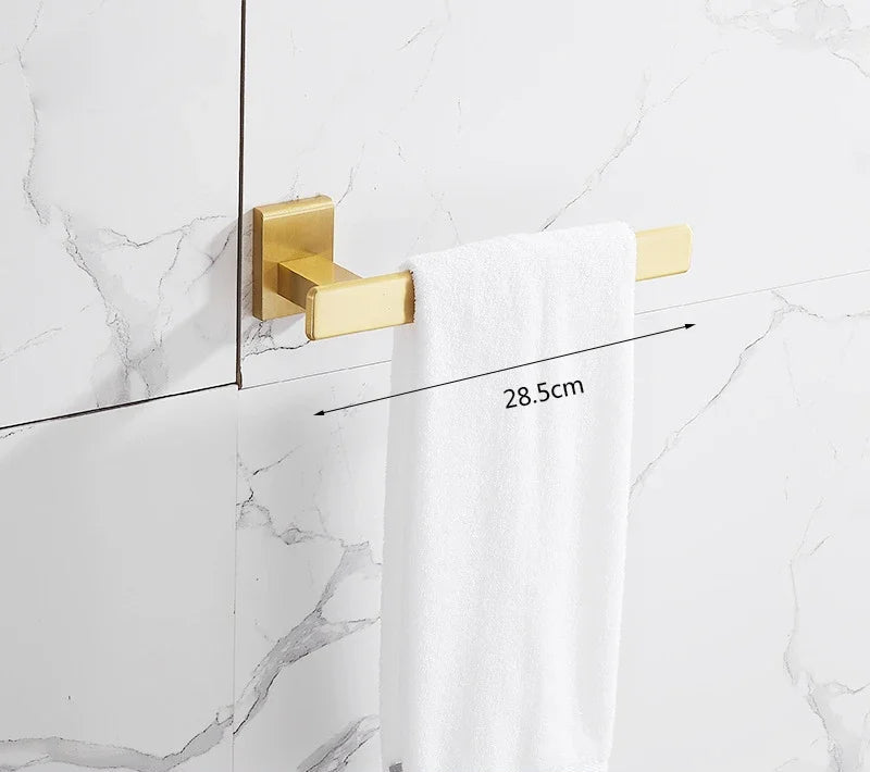 Gold towel hook on a marble wall with a white towel draped over it, showing measurement details.