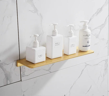 Set of white bottles with pumps on a wooden shelf against a marble wall.