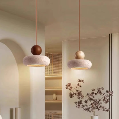 Two modern pendant lights hanging in a room with a neutral color palette.