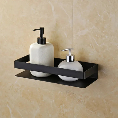 Two white soap dispensers with black and silver pumps on a black wall-mounted shelf against a beige tiled wall.