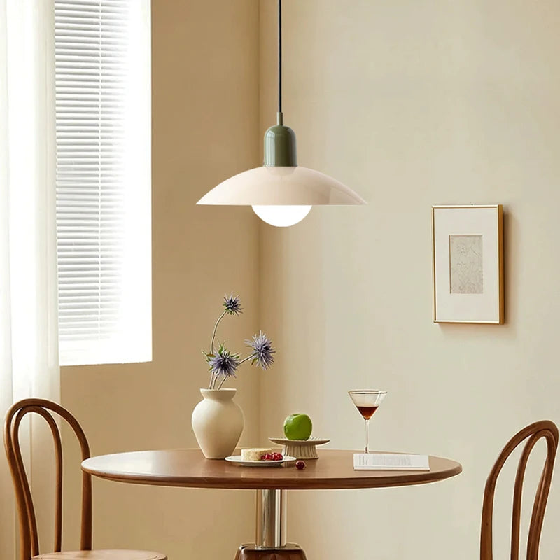 Dining area with a small round table, chairs, and a pendant light.