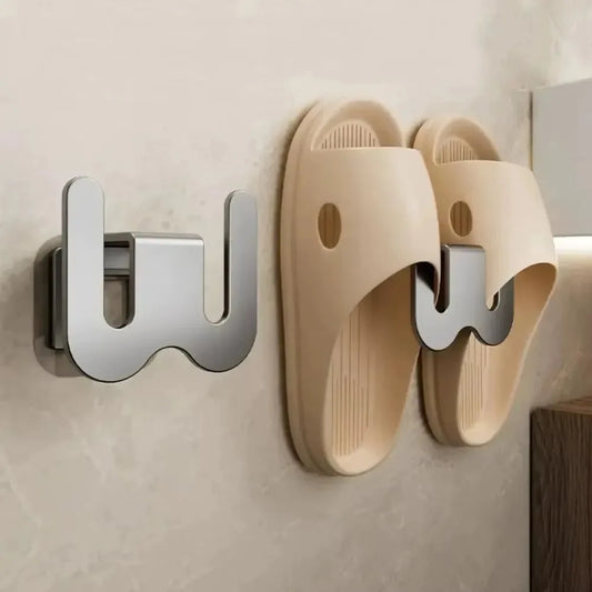 Beige slippers with metal hooks attached to a wall