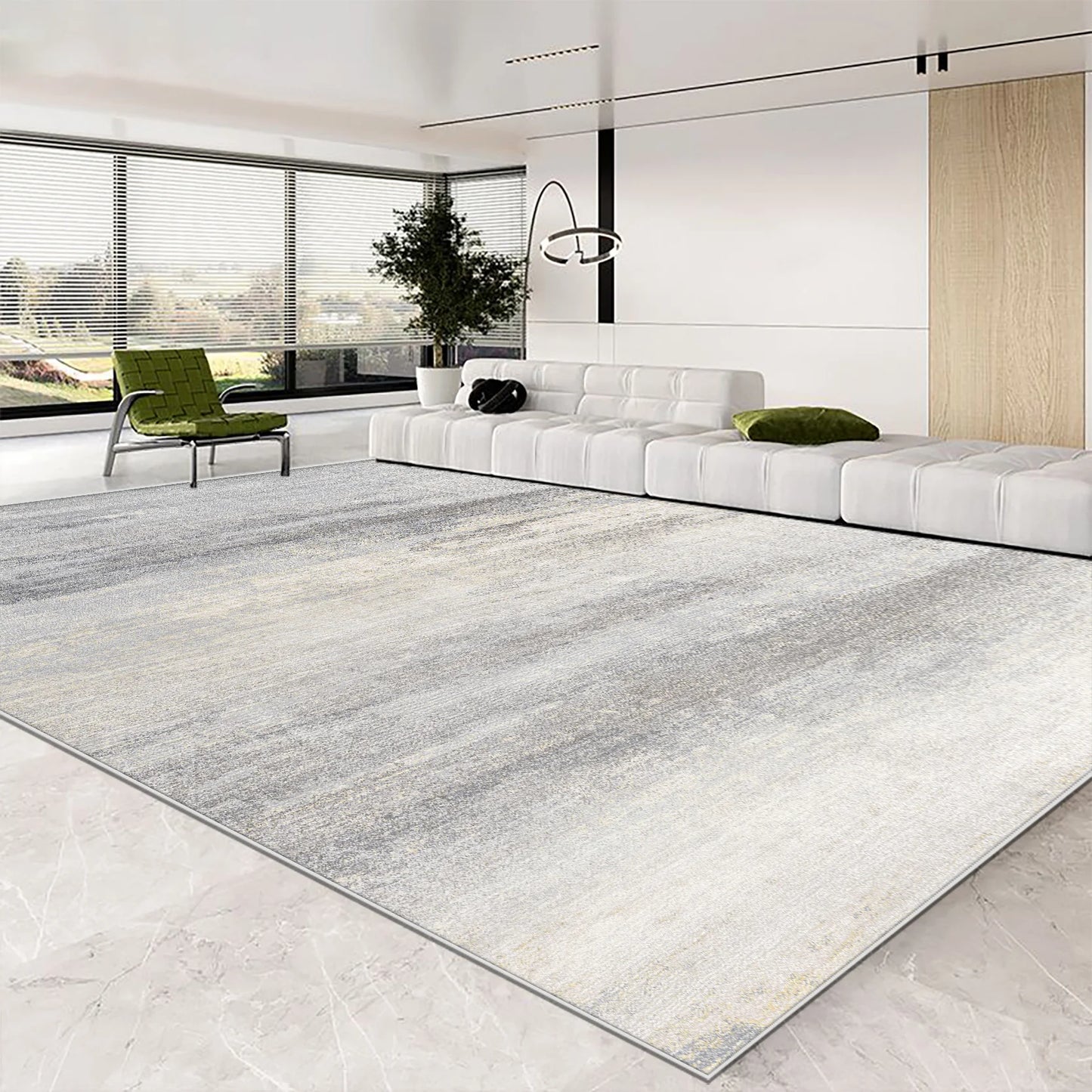 Modern living room with a large area rug, white sofa, and green chair.