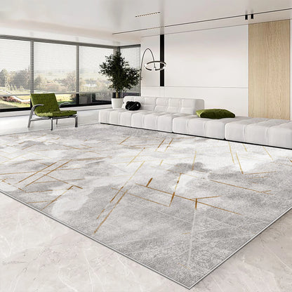 Modern living room with a geometric patterned rug, white sofa, and green chair.