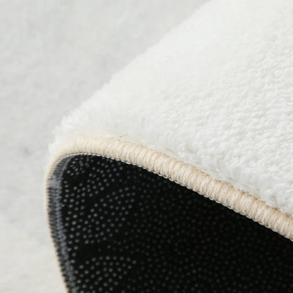 Close-up of a white rug with a textured border on a light gray background