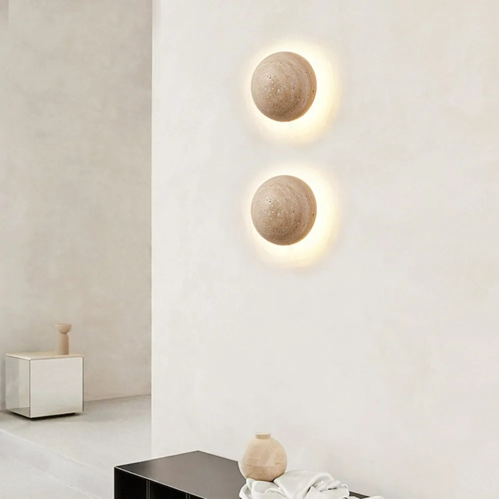 Two round wall lights on a white wall with minimal decor.