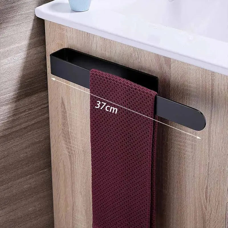 Black towel rack with a maroon towel on a wooden bathroom cabinet.