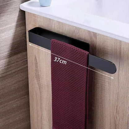 Black towel rack with a maroon towel on a wooden bathroom cabinet.